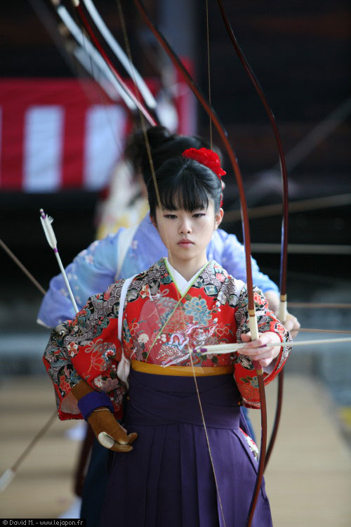 Jeune femme japonaise de 20 ans tirant à l'arc pendant le festival Toh-shiya au temple Sanjusangen-do à Kyoto Japon